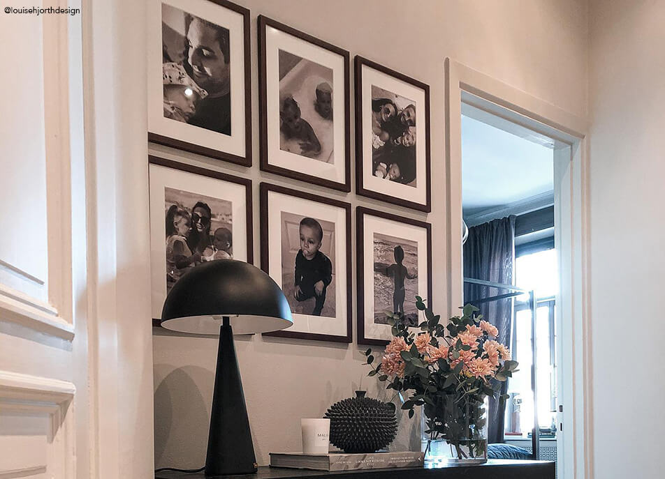 Fotowand im Flur, schwarzweiße Fotos in dunklen Holzrahmen